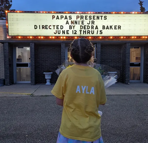 Ayla Looking At The Annie Jr Marquee