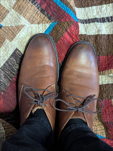 My nice shoes got a little sad tongue Nice leather shoes being worn with black socks while standing on a beautiful wood themed quilt, the left shoe has had…