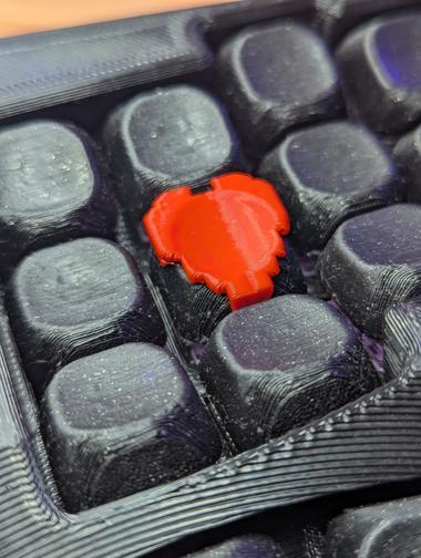 heart of a macropad A pixel heart kecap in the center of a macropad, the macropad is admittedly dirty, filled with small bits of fuzz.