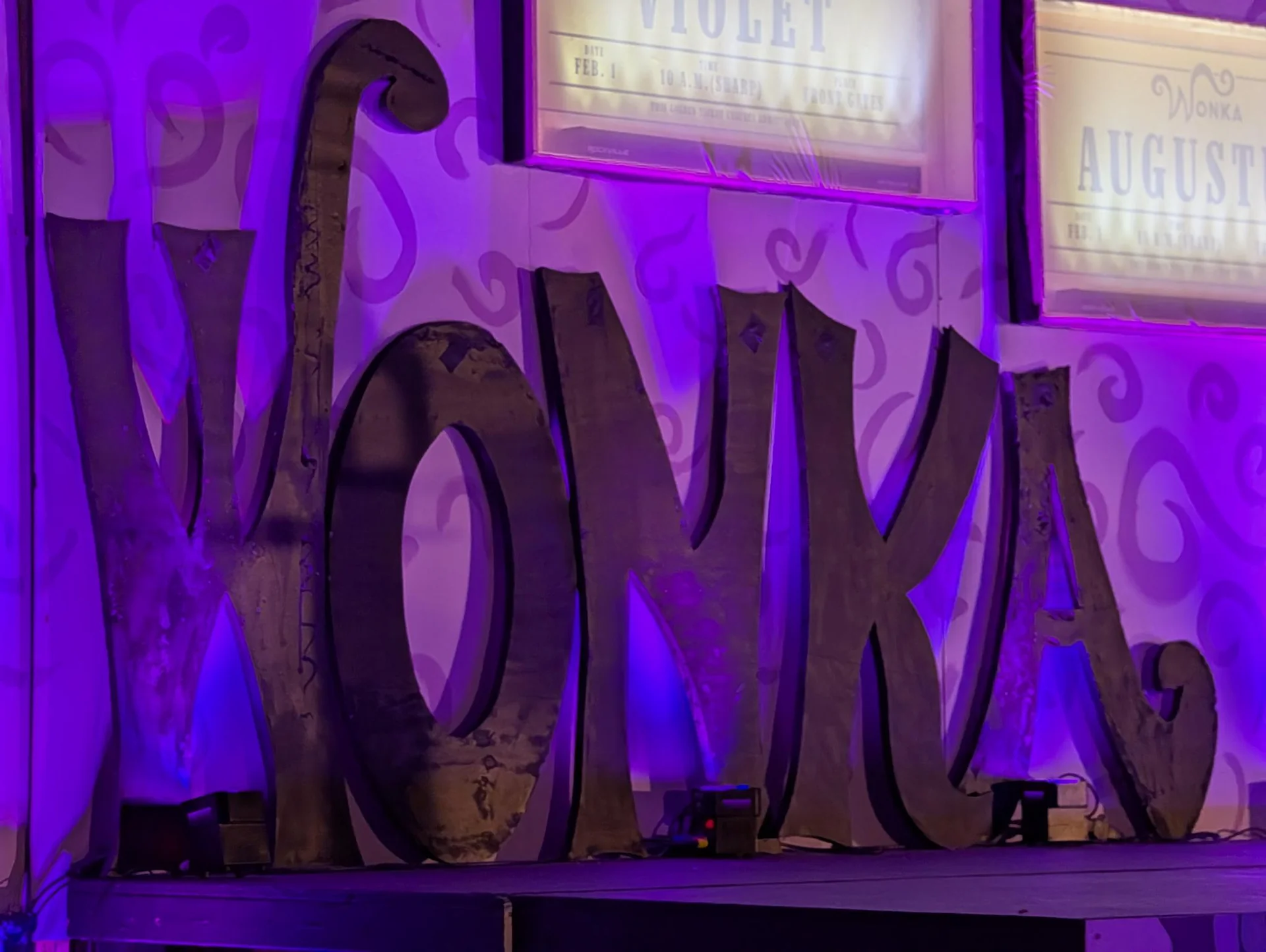Large letters spelling WONKA under purple light
