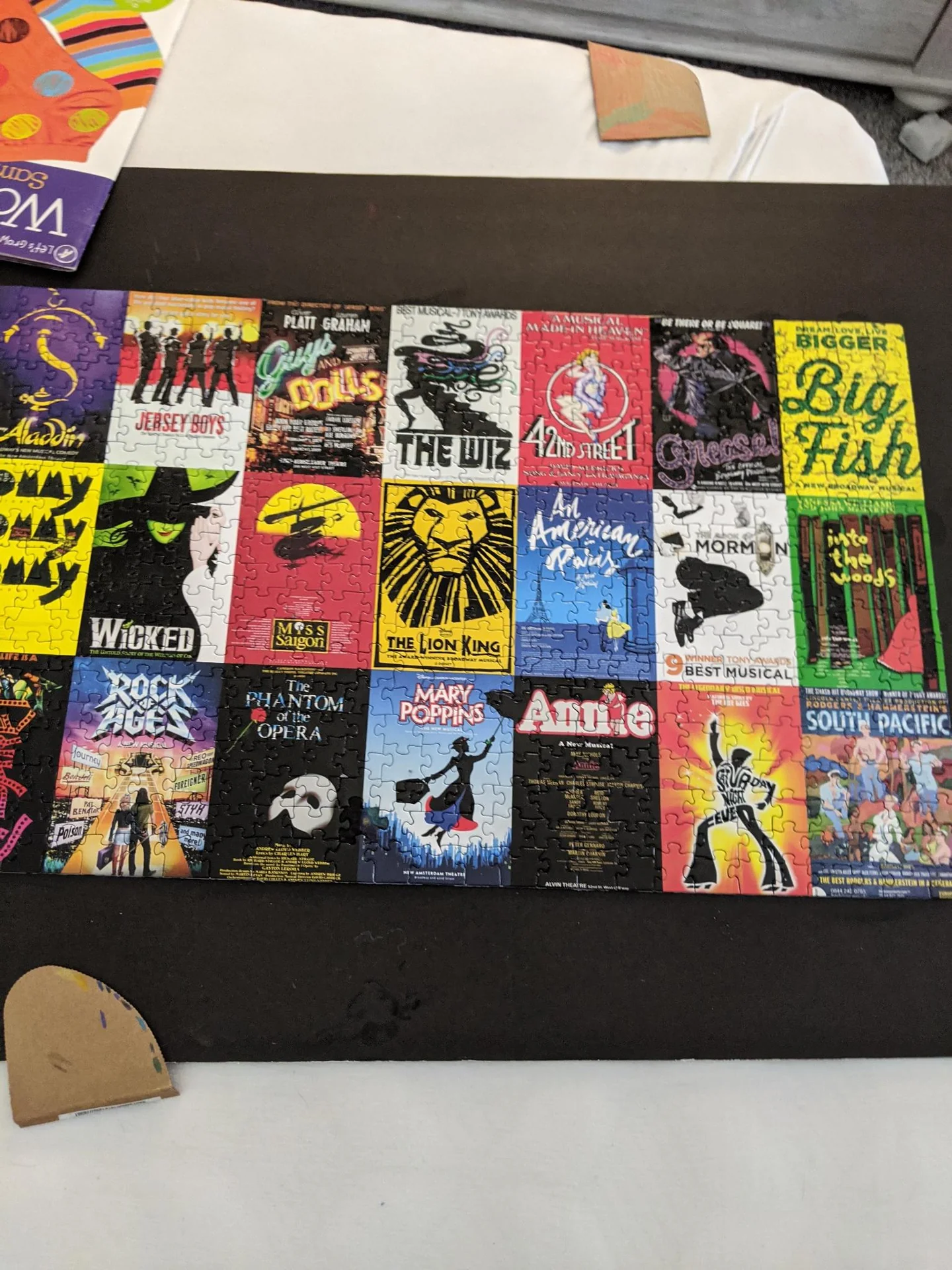 Completed jigsaw puzzle showing musical theater posters
