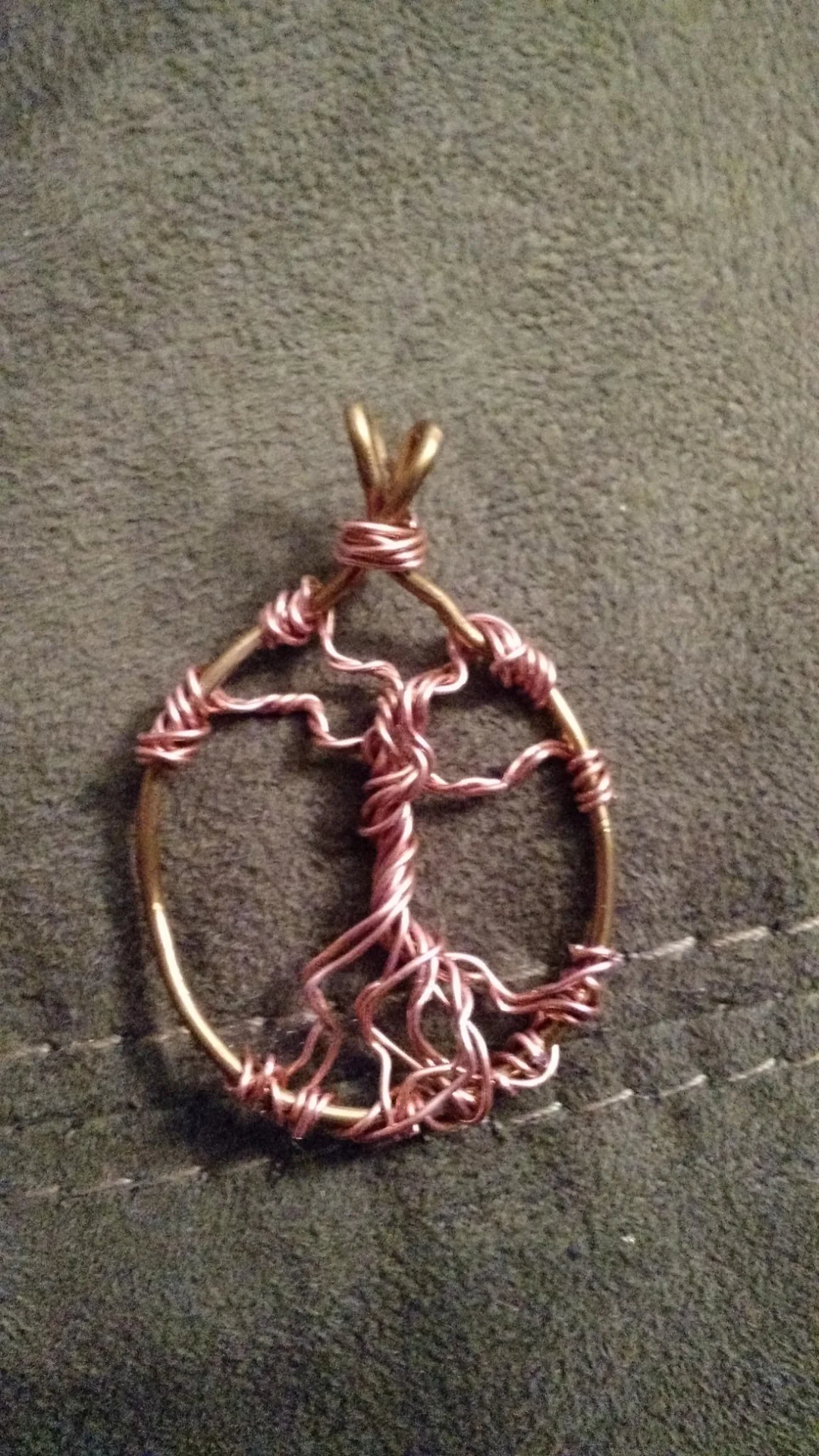Copper wire tree pendant on dark fabric