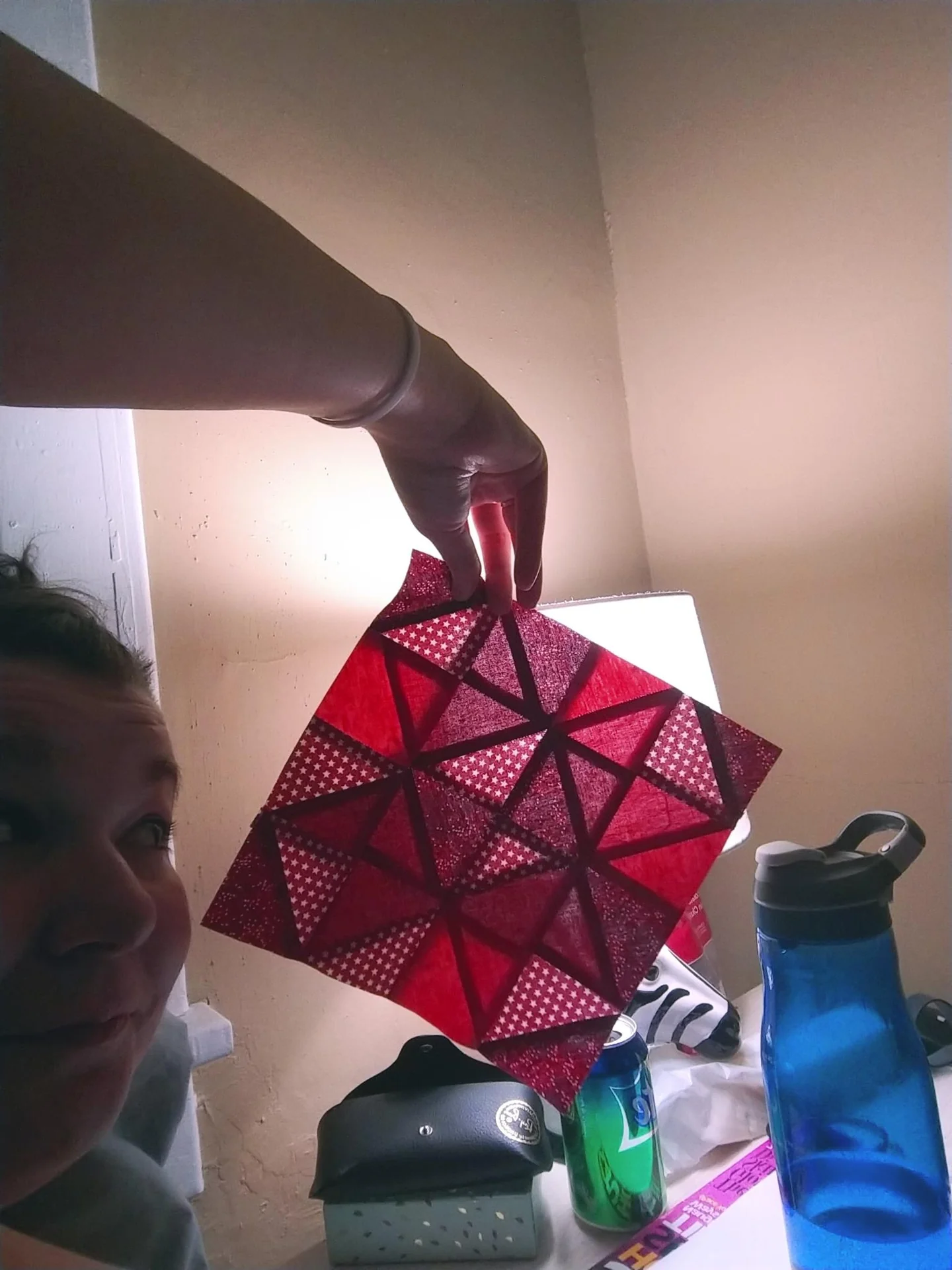 Red geometric ornament held up by one corner