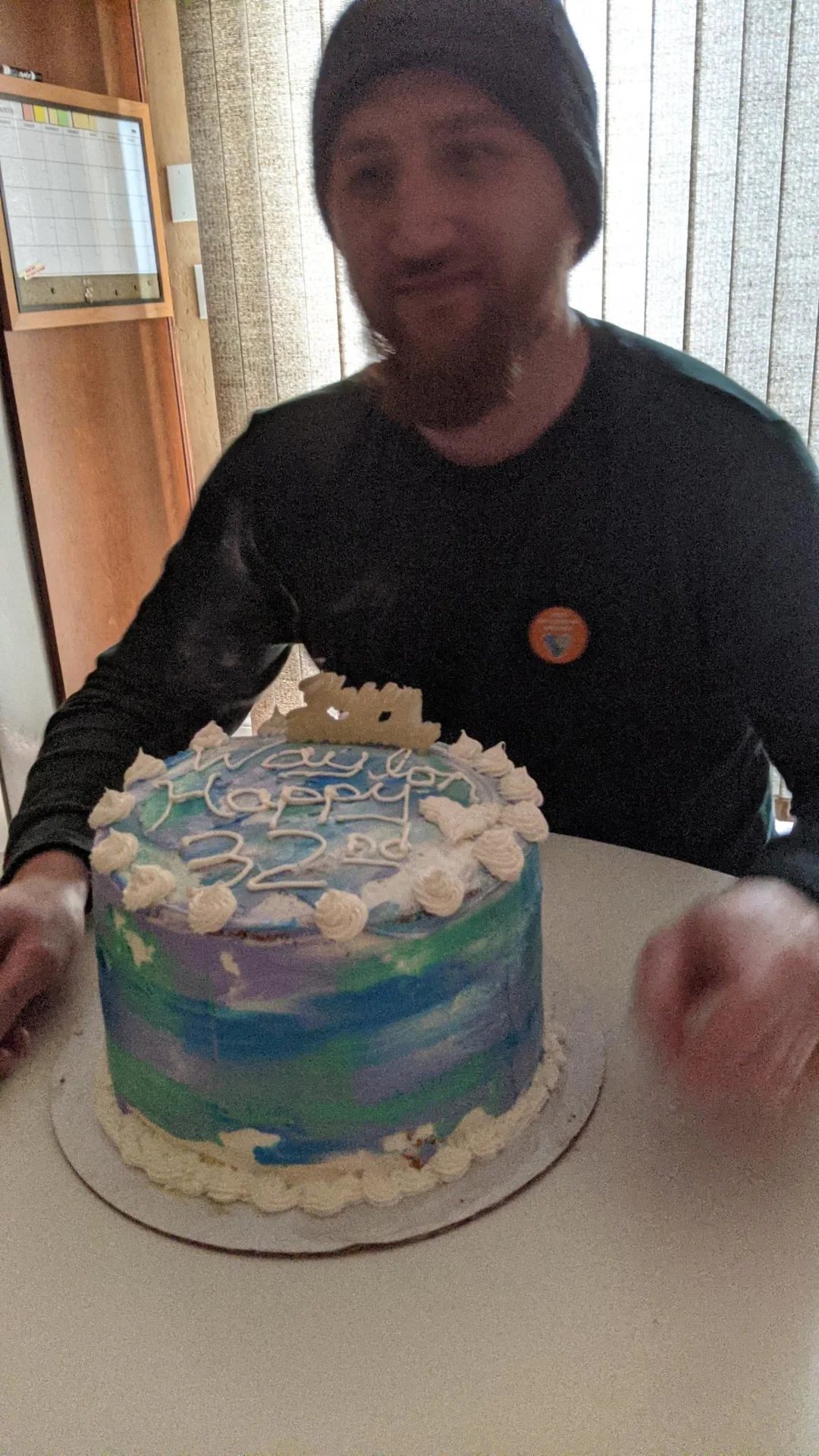 Man holding a blue and white birthday cake