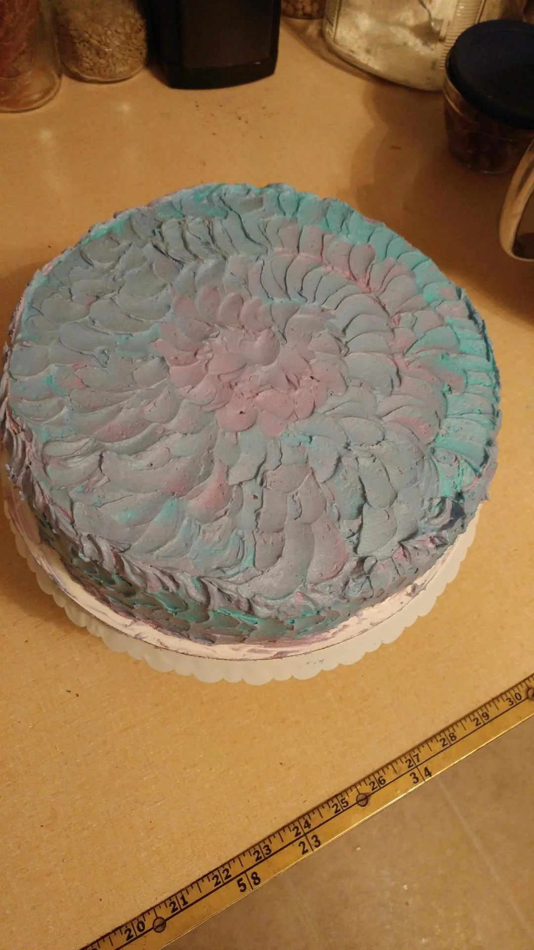 Round cake with pale blue and pink swirled frosting