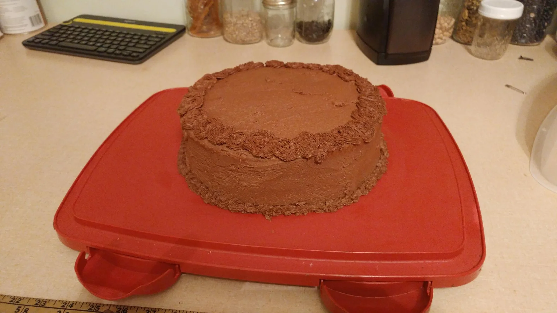 Round chocolate cake on a red tray