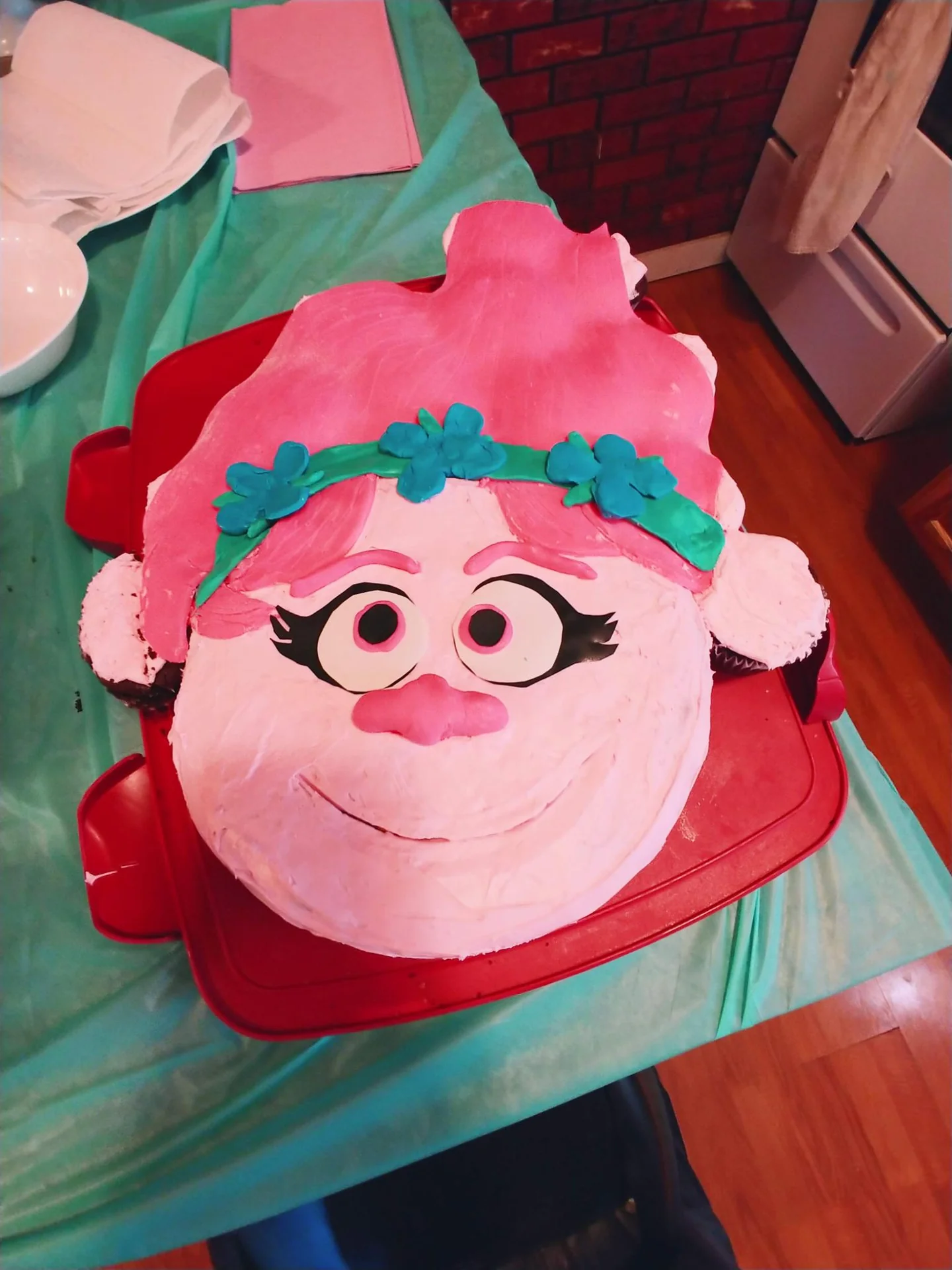 Pink birthday cake shaped like a smiling cartoon character