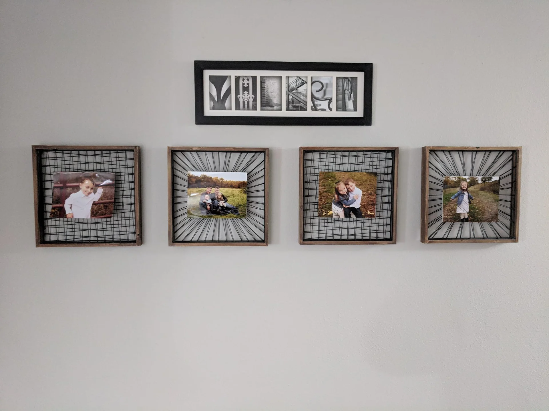 Four framed photos hanging beneath a name sign