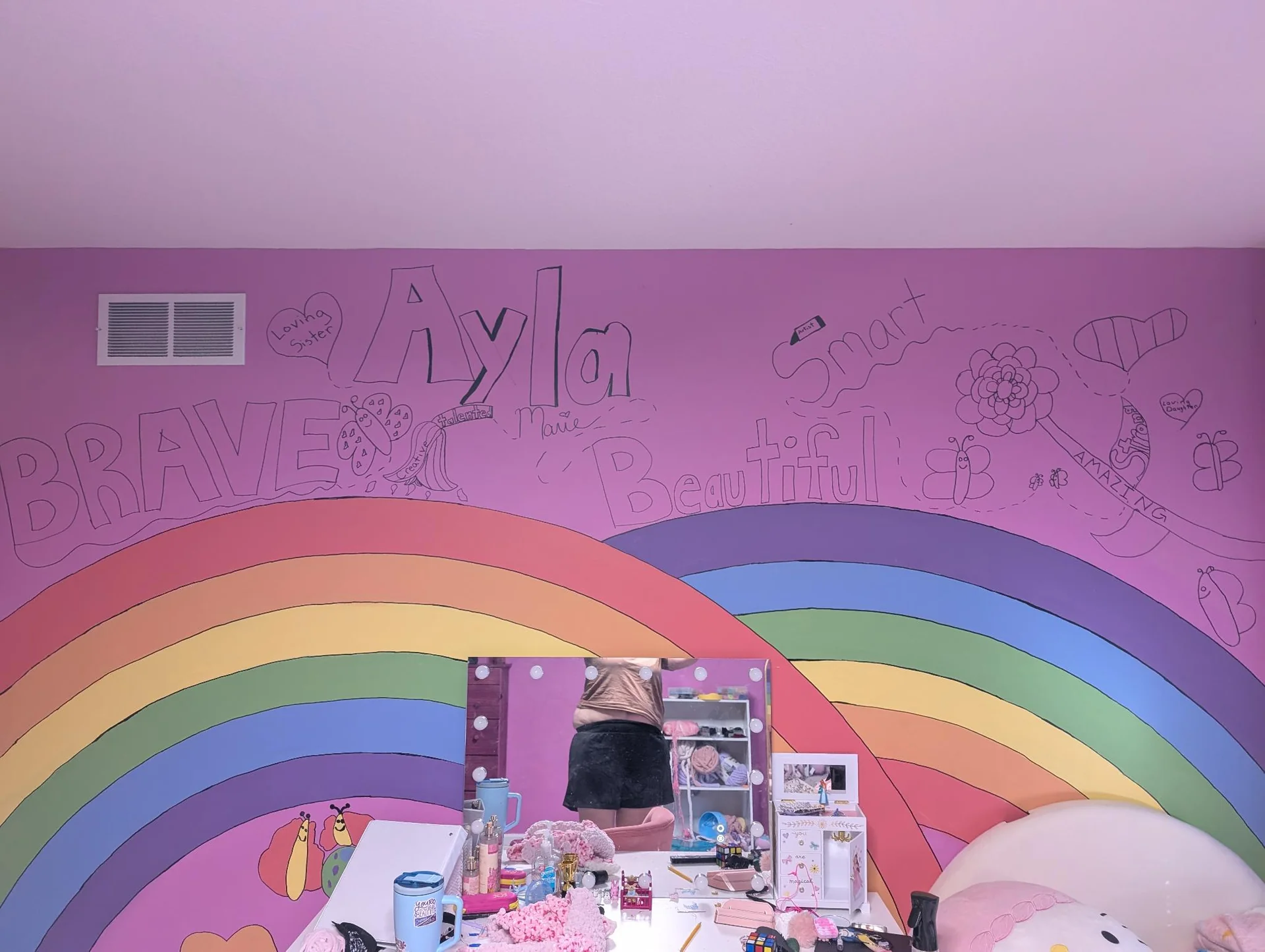 Two rainbow murals across a pink bedroom wall