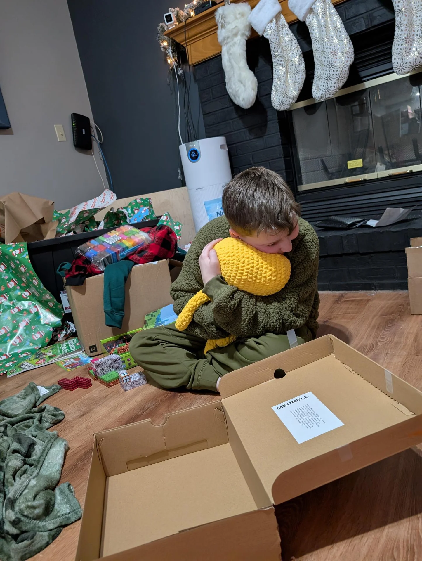 Child holding a yellow crocheted toy at a craft table