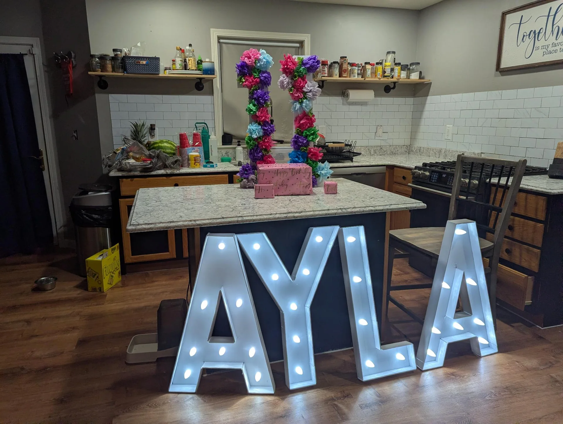 Illuminated letters spelling AYLA on a floor