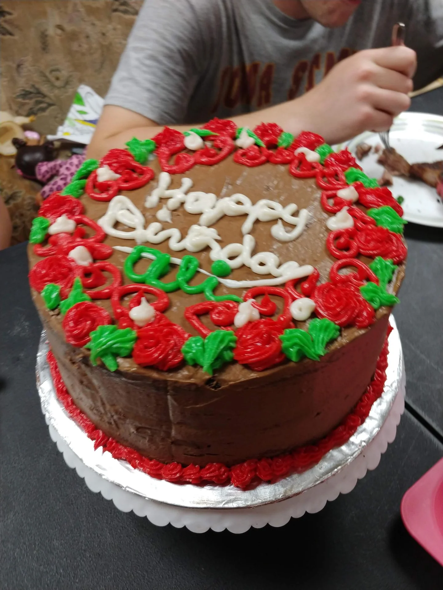 Red birthday cake topped with cream and strawberries