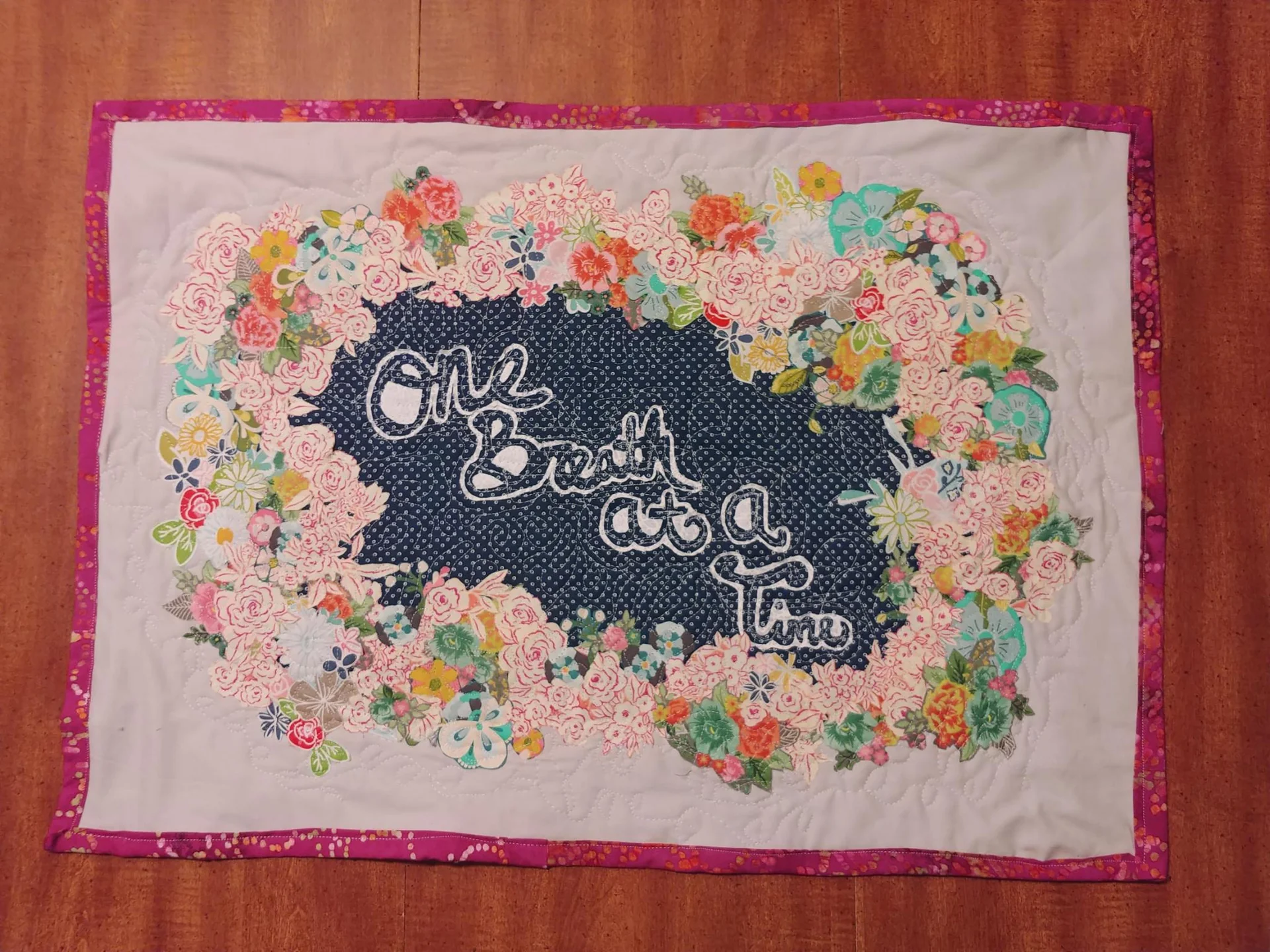 Floral quilt with a dark center and pink border