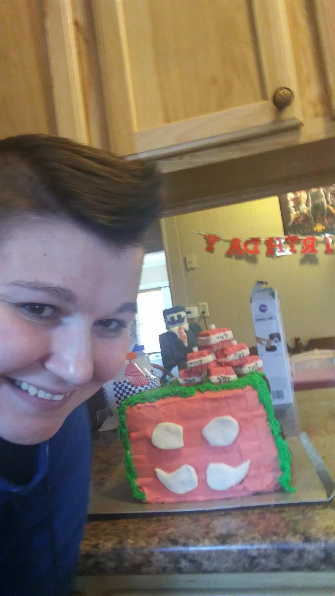 Woman smiling beside a square Minecraft birthday cake