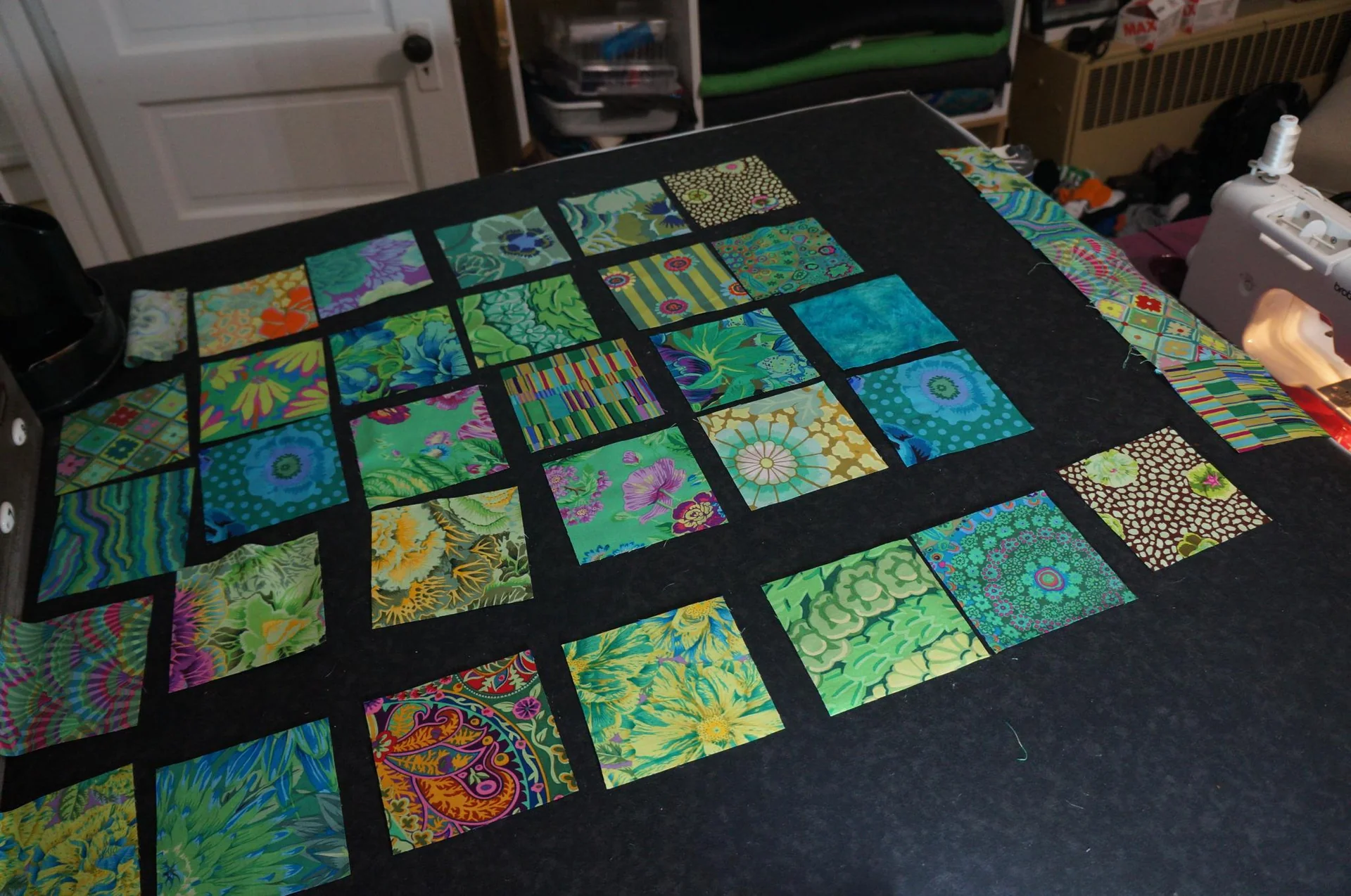 Blue and green patterned quilt blocks arranged on a table