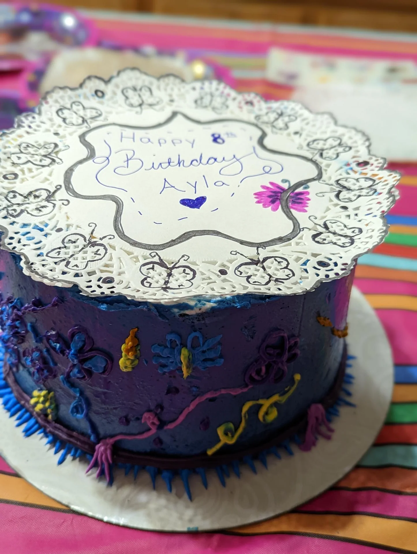 Purple birthday cake with butterflies and a white topper