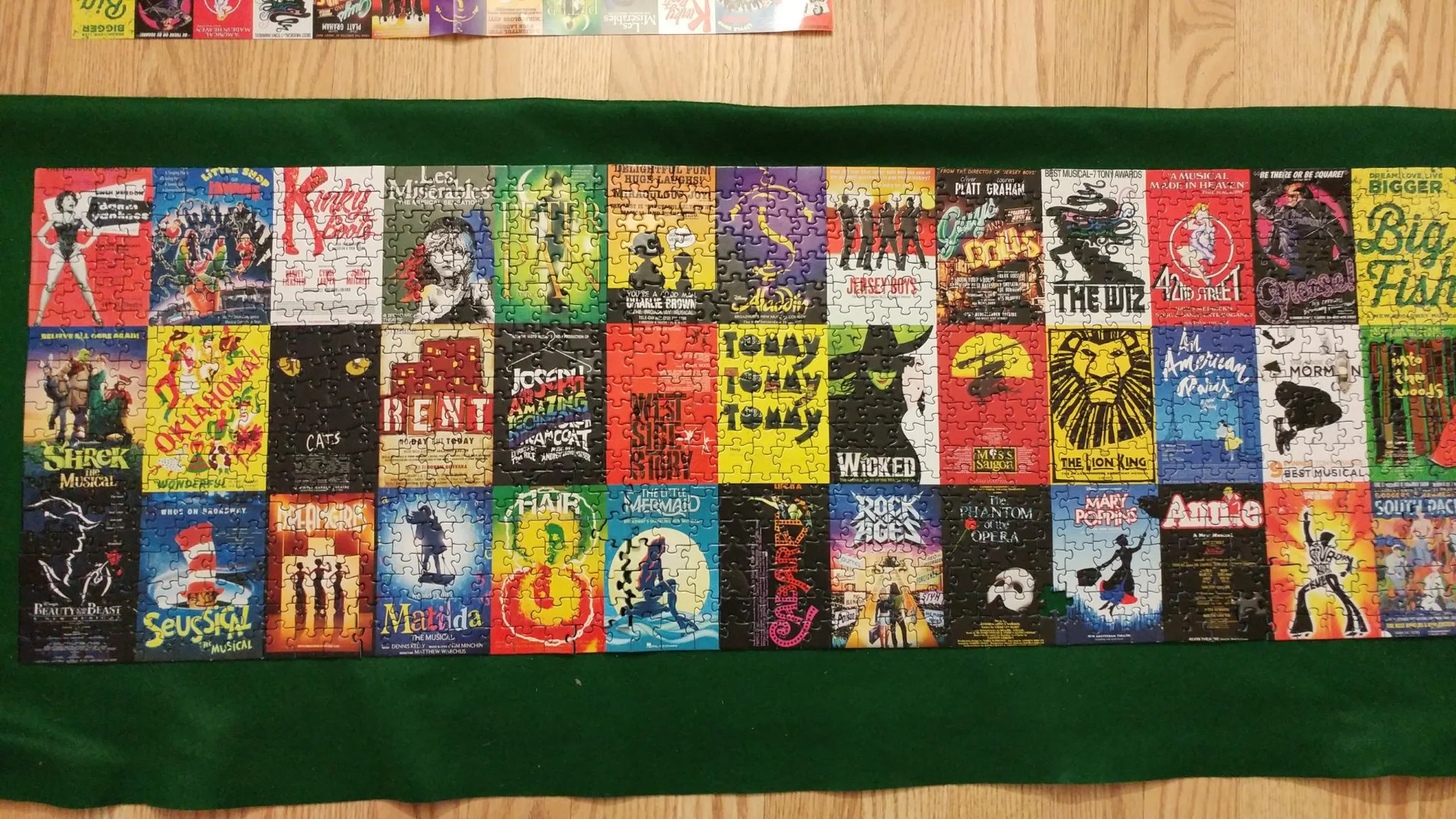 Musical theater poster jigsaw puzzle on green felt
