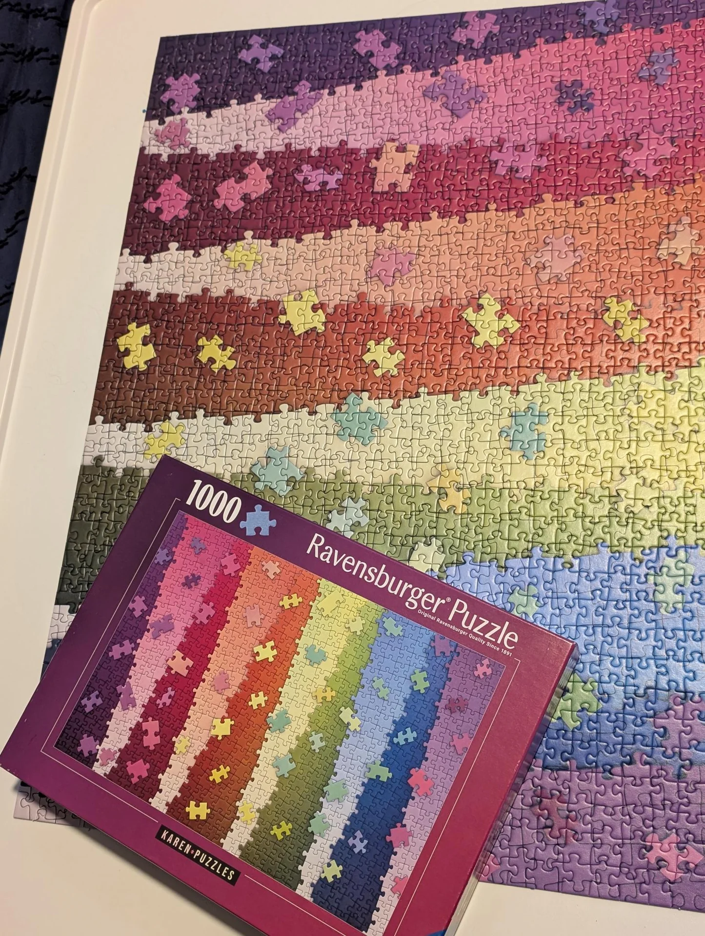 Rainbow-striped jigsaw puzzle beside its box